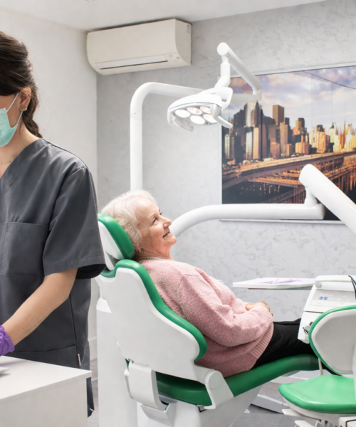 Praxis ZFA schreibt auf den Computer, alte Patientin sitzt auf dem Stuhl-Zahnarztpraxis Zharri