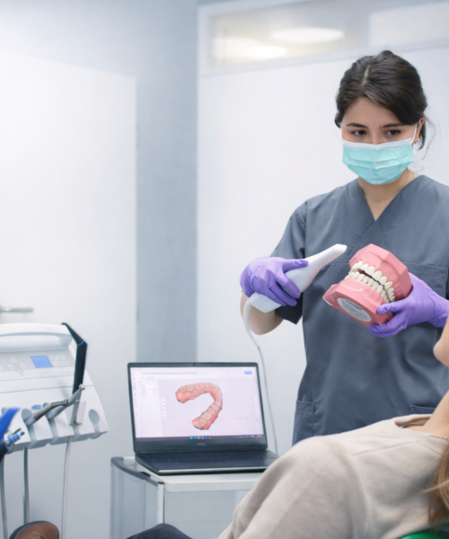 Praxis ZFA zeigt den intraoralen Scanner zur Patientin-Zahnarztpraxis Zharri